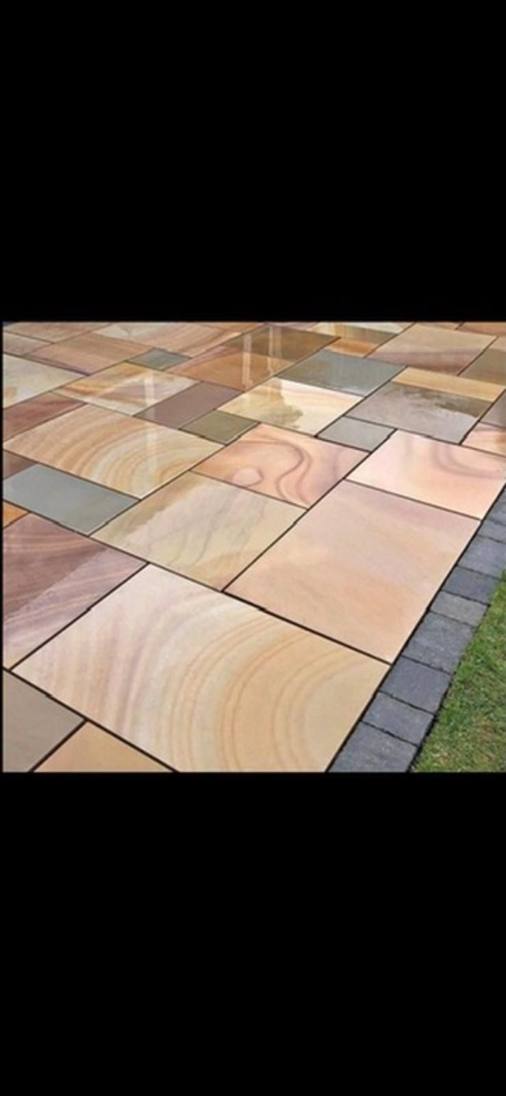 Close-up of a tiled ground surface with variously colored stone slabs in different shades and patterns.